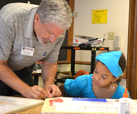 Bob Coverdill helps a camper with her model airplane.